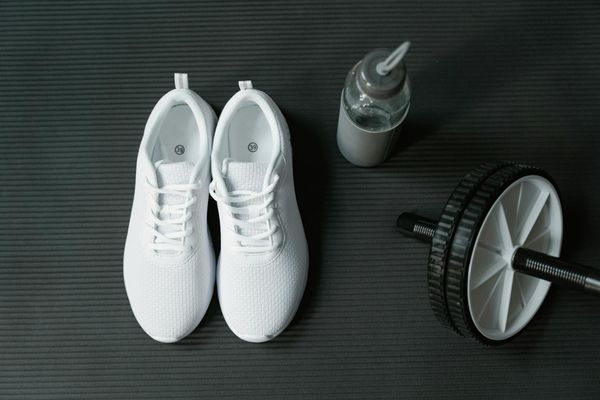 Close up of sports shoes and a bottle of water.